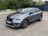 une voiture grise garée dans un parking à côté d'un bâtiment