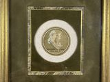 a gold framed picture of a portrait of a man in profile