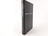 a black book sitting on top of a white table next to a white wall