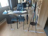 une pièce équipée d'un bureau, de chaises et d'une lampe