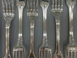 a lot of forks and spoons that are on a table