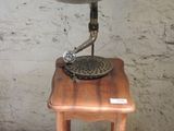 une petite table en bois sur laquelle trône un vieux gramophone