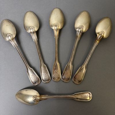 six spoons and a spoon rest on a black surface