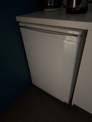 une photo d'un petit réfrigérateur blanc dans une cuisine
