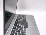 a silver laptop with a black keyboard on a white surface