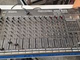 une grande table de mixage posée sur une table, sur laquelle sont posés des écouteurs