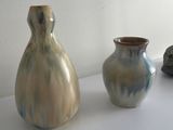 three vases sitting on a white table next to each other