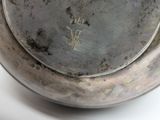 a close up of a metal bowl with writing on it