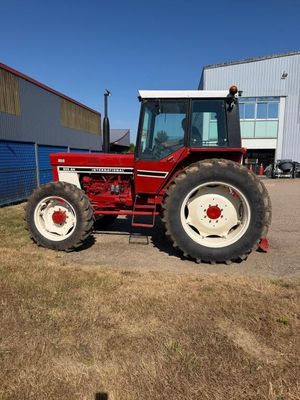 un tracteur rouge garé devant un bâtiment