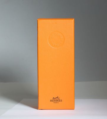 une boîte orange posée sur une table près d'un mur blanc