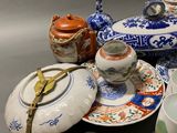 many different types of teapots and saucers on the table