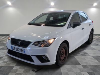 la voiture blanche est garée sur un sol en damier dans le garage