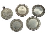 four different types of silver coins are shown on a white surface