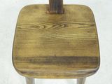 a wooden chair with a wooden seat on a white floor