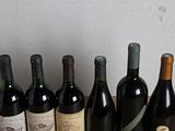 several bottles of wine are lined up on a wooden table