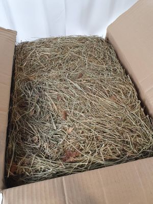 une caisse de foin posée sur une surface blanche