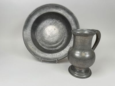 a silver cup and saucer sitting next to each other