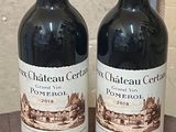 two bottles of wine sitting on a wooden table