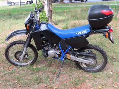 une moto bleue et noire garée dans l'herbe
