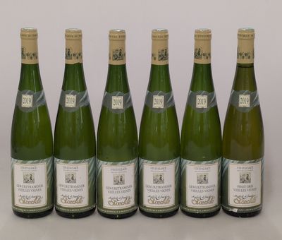 six bouteilles de vin sont alignées sur une table