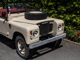 a tan land rover with a red top parked in a parking lot