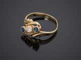 a close up of a gold ring with blue and white stones