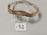 un gros plan d'un bracelet en fil métallique posé sur une surface blanche