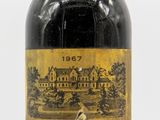 une vieille bouteille de vin posée sur une surface blanche