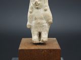 une image représentant une statue d'une personne debout sur un bloc de bois