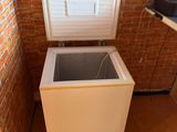 a small white chest freezer in the corner of a room