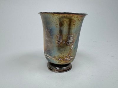 un vase en argent posé sur une surface blanche
