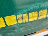a close up of the side of a green bus with yellow stripes