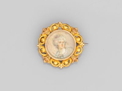 une broche plaquée or représentant le portrait d'une femme