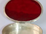 a silver box with a red lid sitting on a white surface