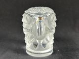a small glass candle holder on a black surface