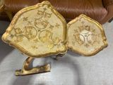 two gold trays sitting on top of a brown chair