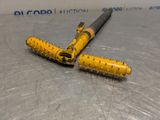 a yellow and black pen laying on a metal surface