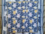 a blue and yellow scarf with white flowers on it