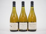 trois bouteilles de vin sont alignées sur une surface blanche