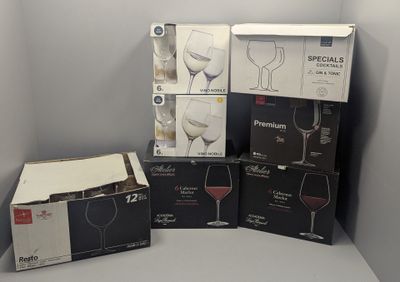 Plusieurs cartons de verres à vin sont empilés les uns sur les autres