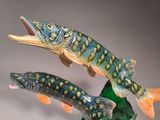 two figurines of fish that are on a table