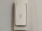 a white light switch that is on the wall