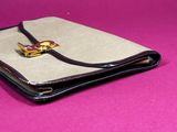 a wallet with a ring on top of it on a pink surface