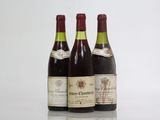 three bottles of wine are lined up on a reflective surface