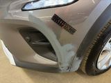 a close up of the front bumper of a car with a denting on it