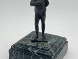 statue of a man holding a book on a marble base
