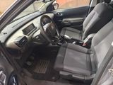 the interior of a car with the door open and the driver ' s seat down