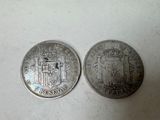 two silver coins sitting side by side on a white surface