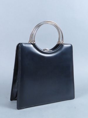 sac à main en cuir noir avec une poignée en métal sur fond blanc