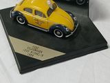 a yellow toy car and a black toy car on a table